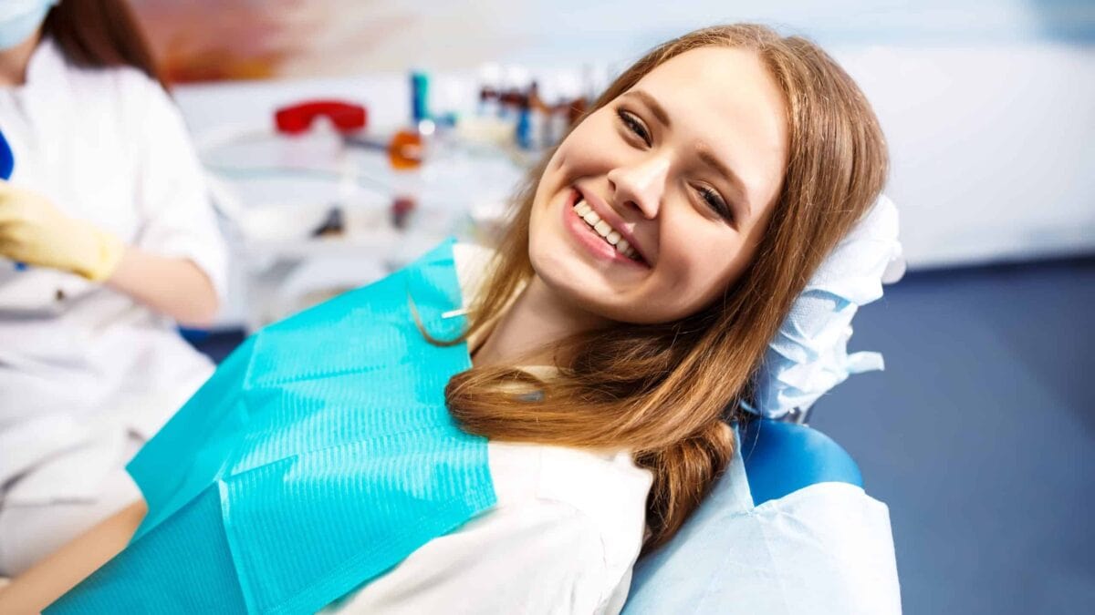 Female patient smiling in a dentist chair.