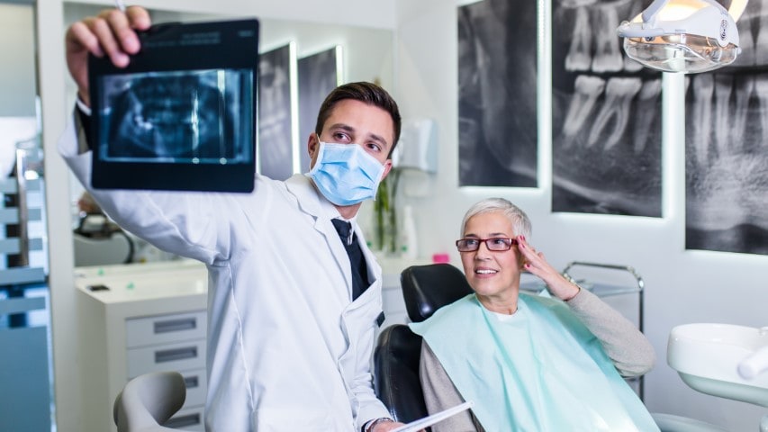 Endodontist and patient looking at x-ray