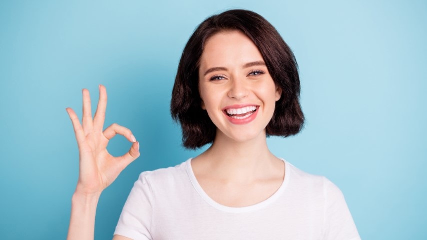 Smiling woman showing ok-sign.
