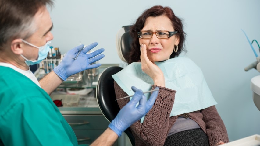 Woman with toothache sitting in dental chair